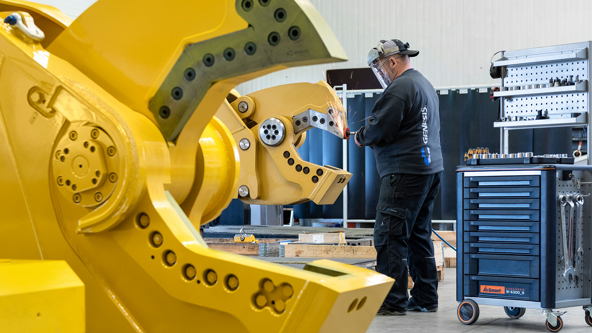 Genesis service technician performing maintenance work on the jaws of a hydraulic shear