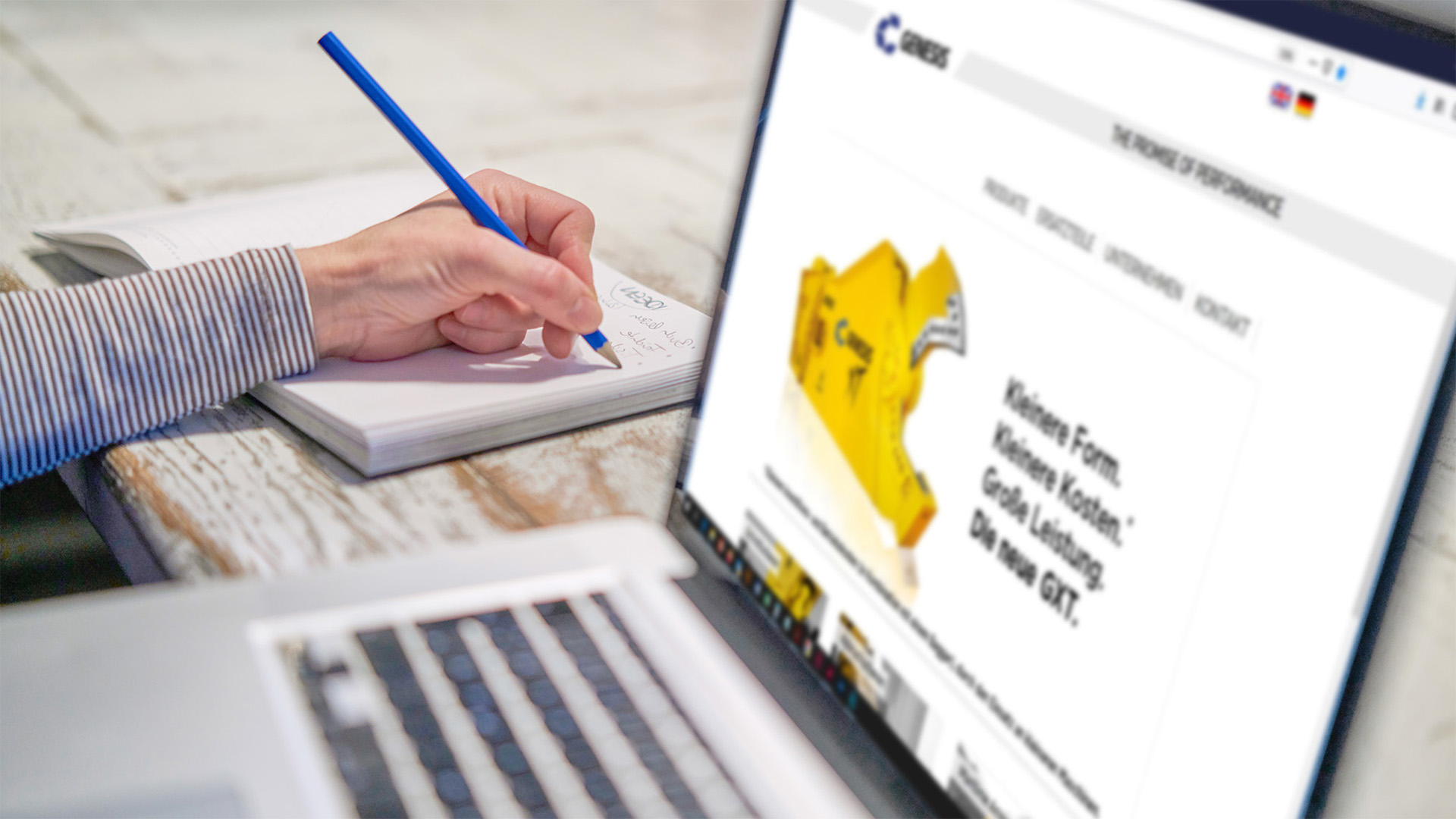 Person macht Notizen neben einem Laptop mit geöffneter Genesis Europe Website
