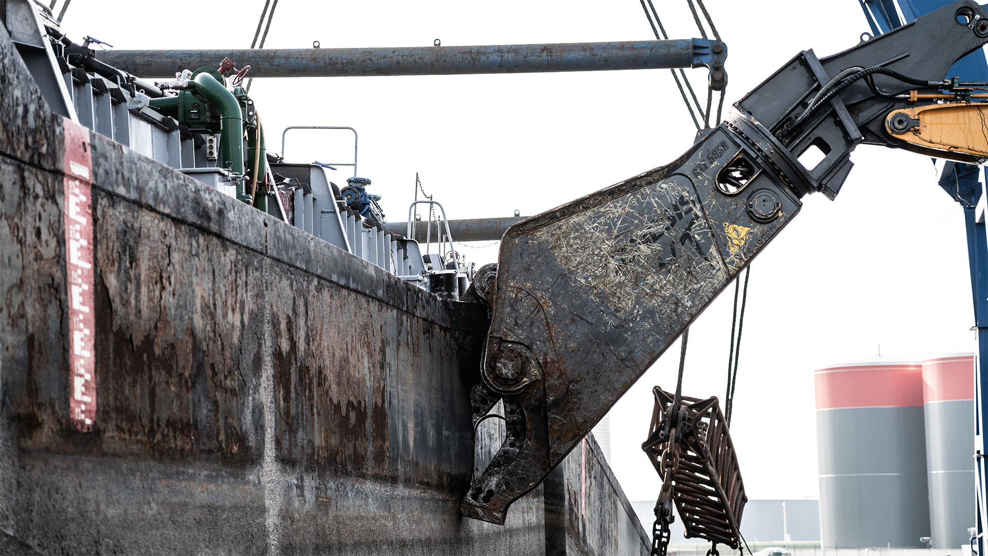 schiffsabwrackung Hydraulische Schere beim Zerschneiden eines Schiffsrumpfs im Schiffsrecycling