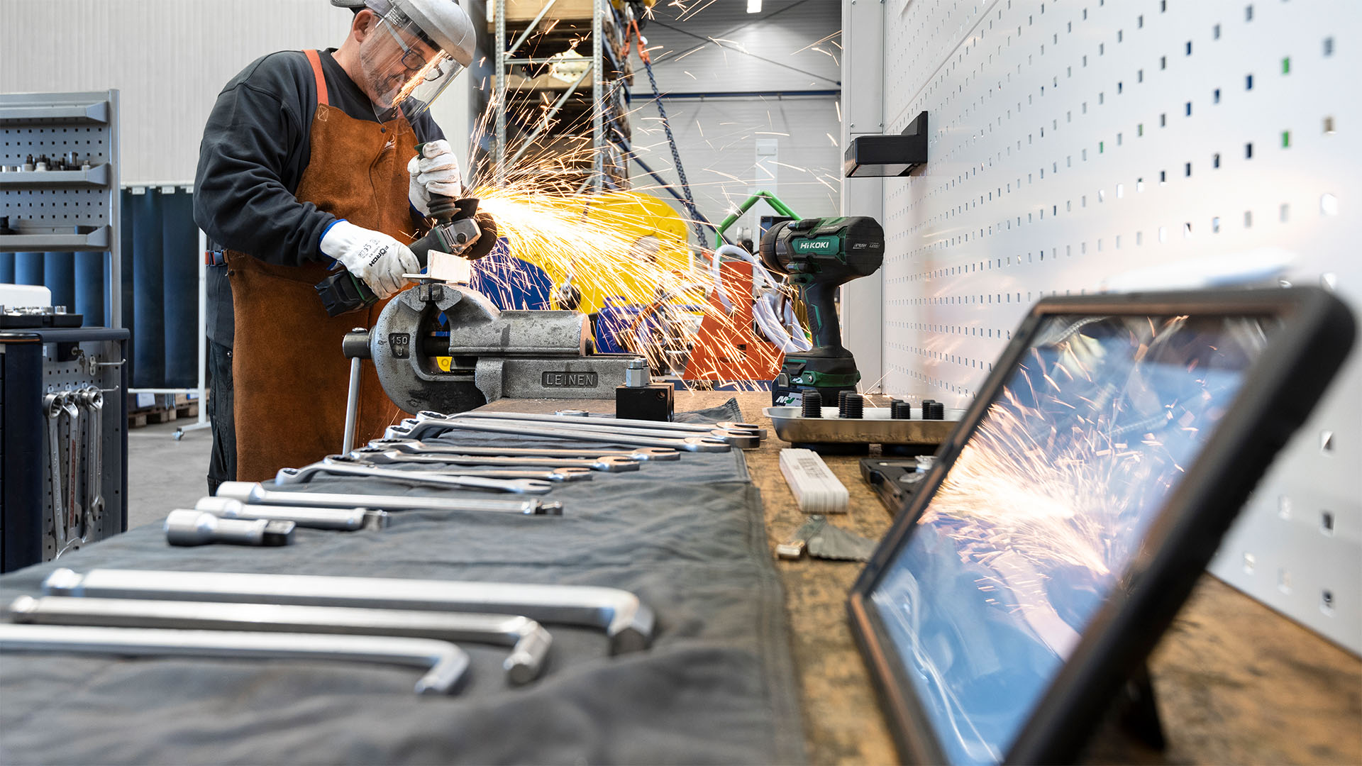 Servicearbeiten an Genesis Scheren Genesis Servicetechniker bei Schleifarbeiten an einem Bauteil in der Servicewerkstatt